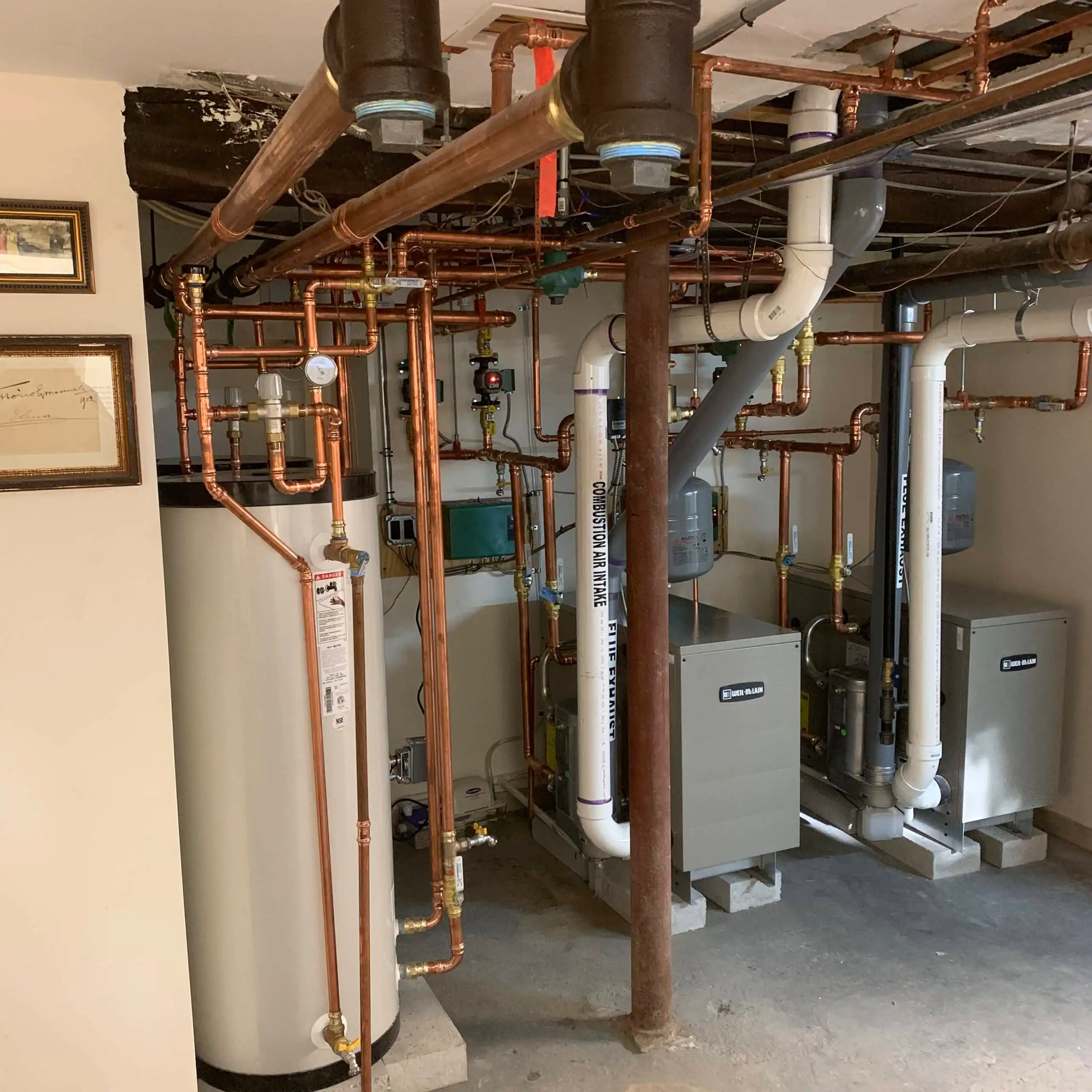 Boiler-8-scaled Modern plumbing system with copper pipes and water heaters in a basement.