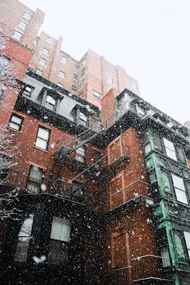 ma-winter Snow falling on a colorful brick apartment building in winter.