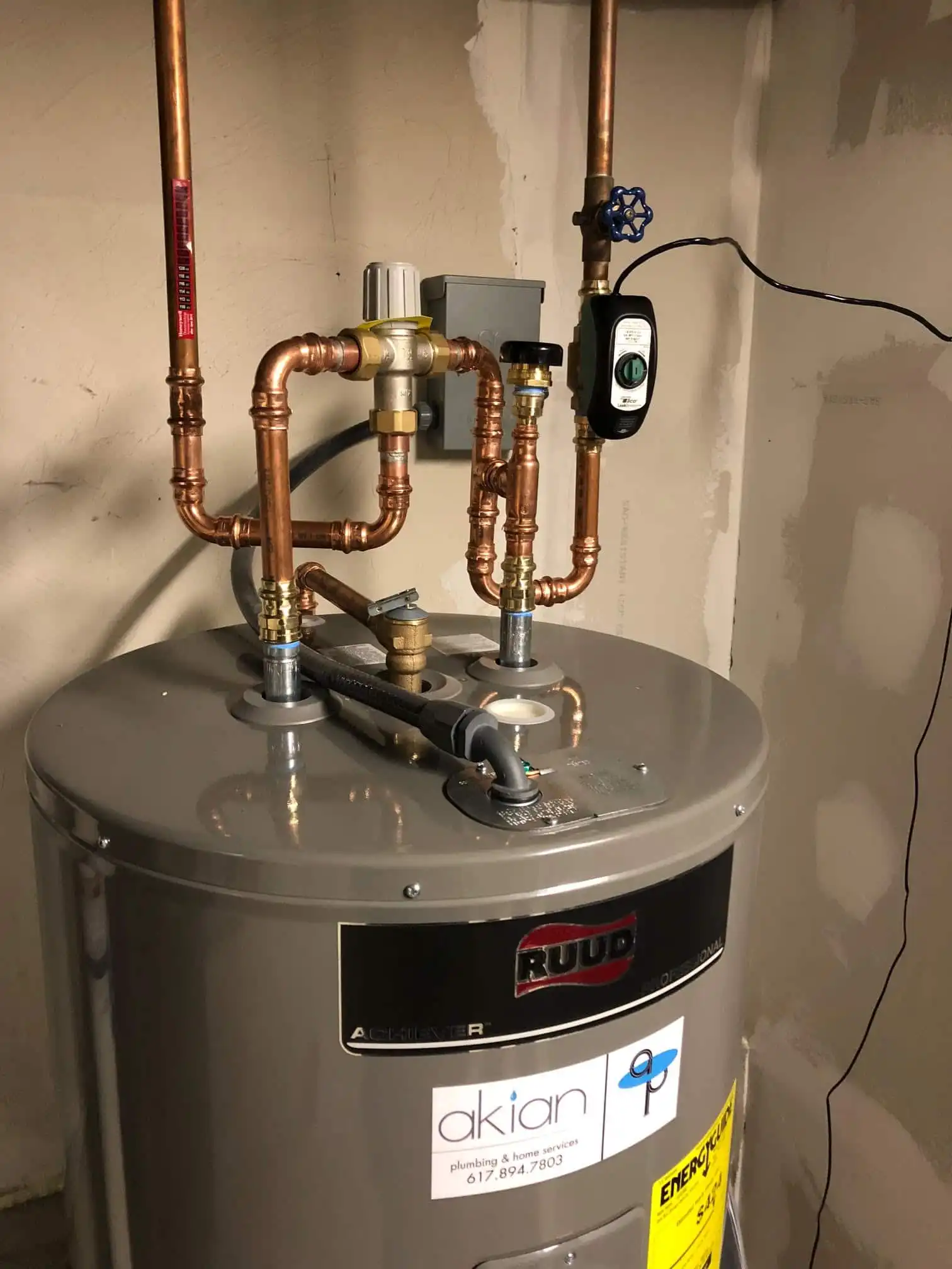 Ruud water heater with copper pipes and control panel installed in Weston MA.