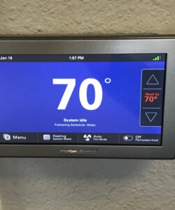 Smart thermostat display showing 70°F and system status.